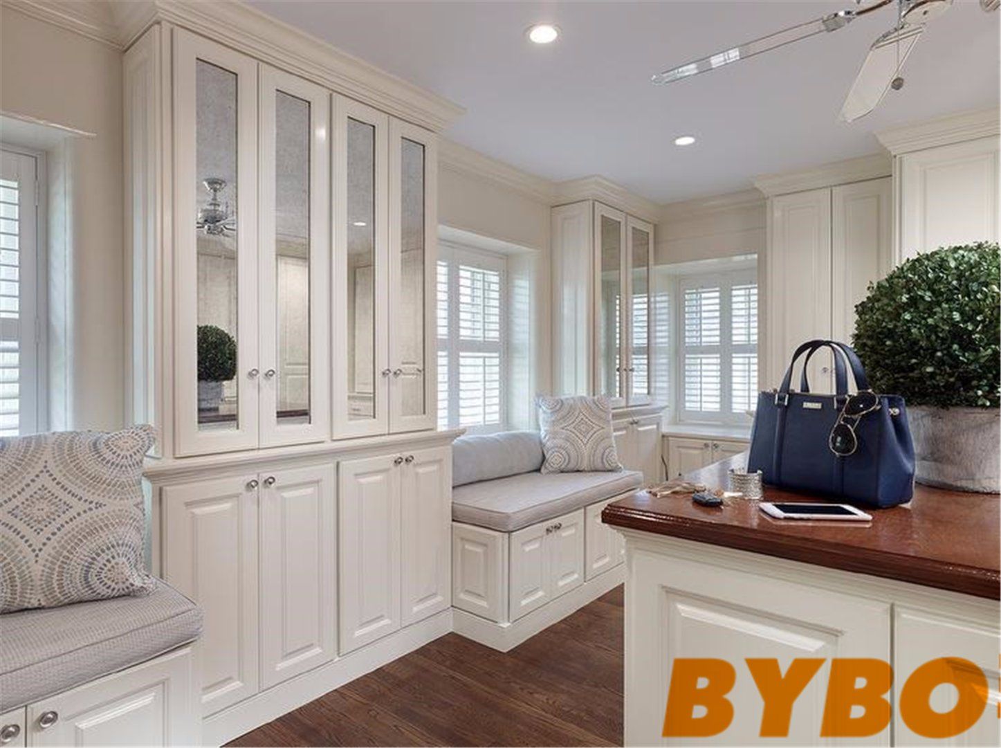 Walk in Closet with Antiqued Mirrored Cabinets and Glossy Wood Closet Island Countertop (BY-W-69)